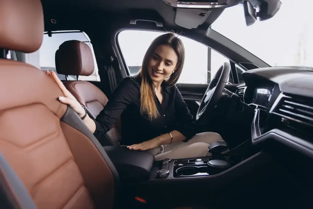 A woman is sitting in a used car.